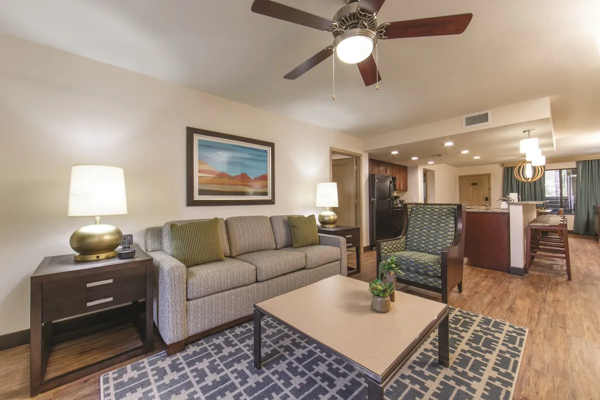 A spacious, inviting living room featuring a plush sofa, stylish coffee table, ambient lighting from a lamp, comfortable chairs, and tasteful wall art. The layout and furnishings create an atmosphere ideal for relaxing, socializing, or entertaining guests. The arrangement encourages group gatherings, perfect for movie nights or board games as described in the content.